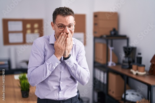 Canvastavla Young hispanic man at the office laughing and embarrassed giggle covering mouth