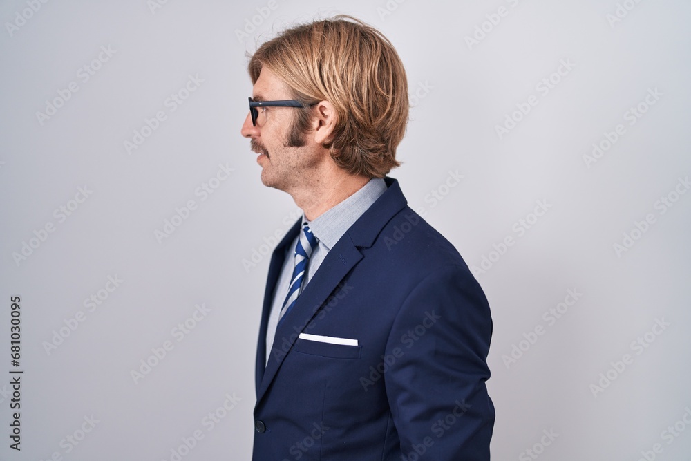 Caucasian man with mustache wearing business clothes looking to side, relax profile pose with natural face and confident smile.