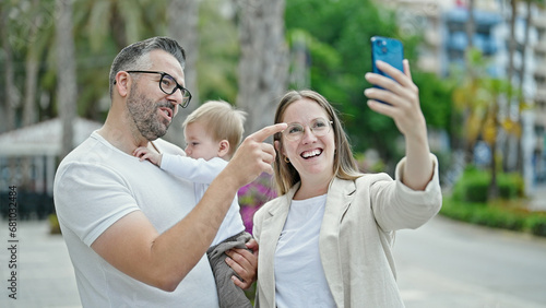 Family of mother, father and baby smiling taking selfie with the phone at street © Krakenimages.com