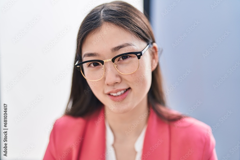 Chinese woman business worker smiling confident sitting on table at office Chinese woman business worker smiling confident sitting on table at office