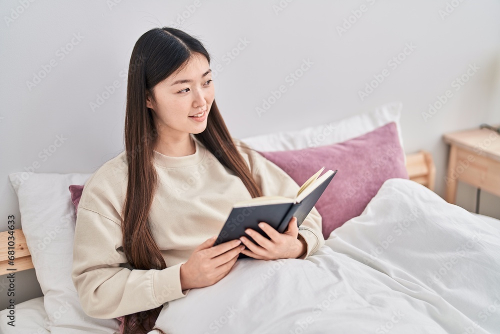 Chinese woman reading book sitting on bed at bedroom Chinese woman reading book sitting on bed at bedroom