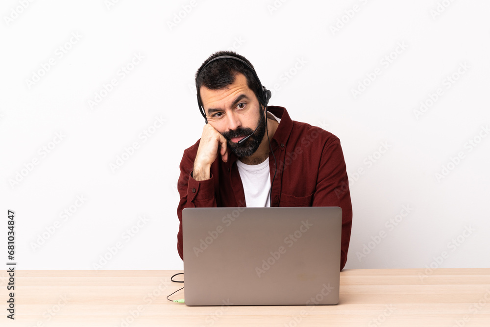Telemarketer caucasian man working with a headset and with laptop with tired and bored expression. Telemarketer caucasian man working with a headset and with laptop with tired and bored expression.