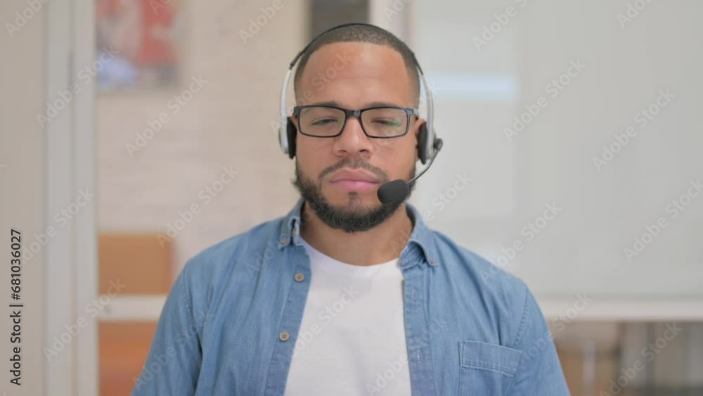 African Man with Headset Looking at Camera in Call Center African Man with Headset Looking at Camera in Call Center