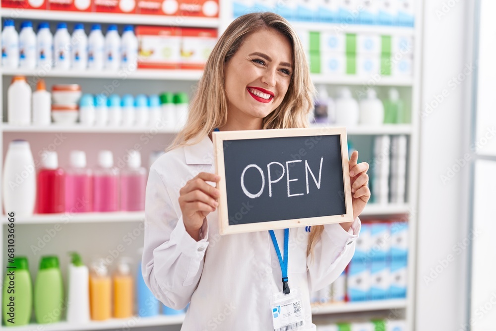 Young beautiful hispanic woman pharmacist smiling confident holding open blackboard at pharmacy