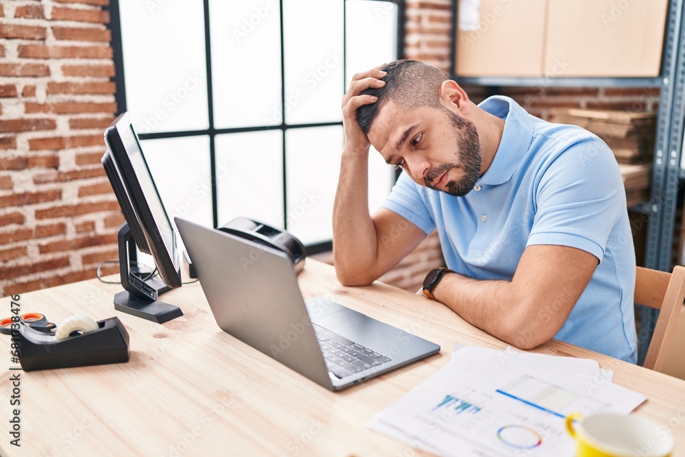 Young latin man ecommerce business worker stressed using laptop at office Young latin man ecommerce business worker stressed using laptop at office