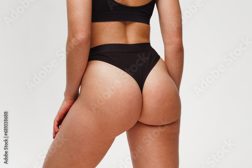 A woman with a beautiful feminine figure in black lingerie with overweight, cellulite and stretch marks. photo