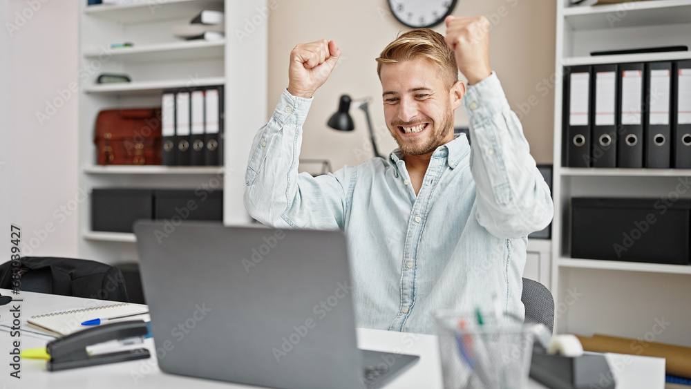 Young caucasian man business worker using laptop working with winner expression at office Young caucasian man business worker using laptop working with winner expression at office