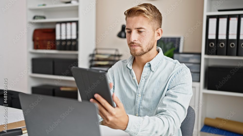 Young caucasian man business worker using touchpad and laptop at office
