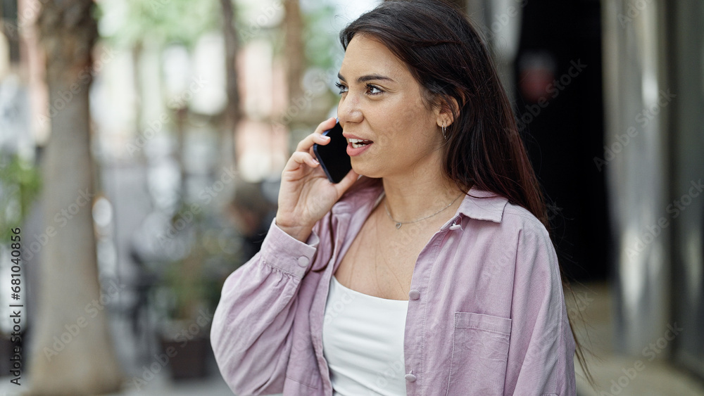 Young beautiful hispanic woman talking on smartphone with serious expression at street Young beautiful hispanic woman talking on smartphone with serious expression at street