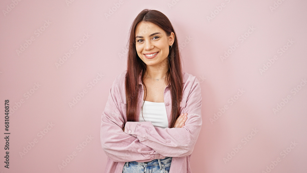 Young beautiful hispanic woman standing with crossed arms over isolated pink background Young beautiful hispanic woman standing with crossed arms over isolated pink background