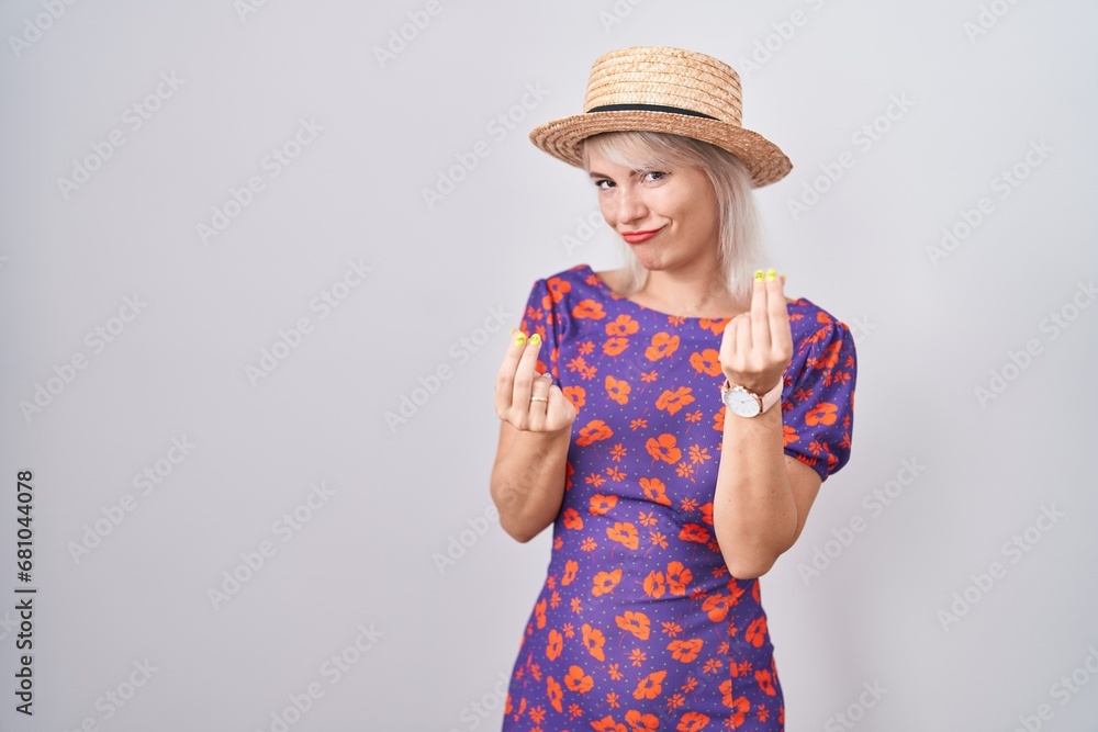 Young caucasian woman wearing flowers dress and summer hat doing money gesture with hands, asking for salary payment, millionaire business Young caucasian woman wearing flowers dress and summer hat doing money gesture with hands, asking for salary payment, millionaire business