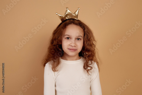 Fotografie Little African-american girl with long curly hair on beige background
