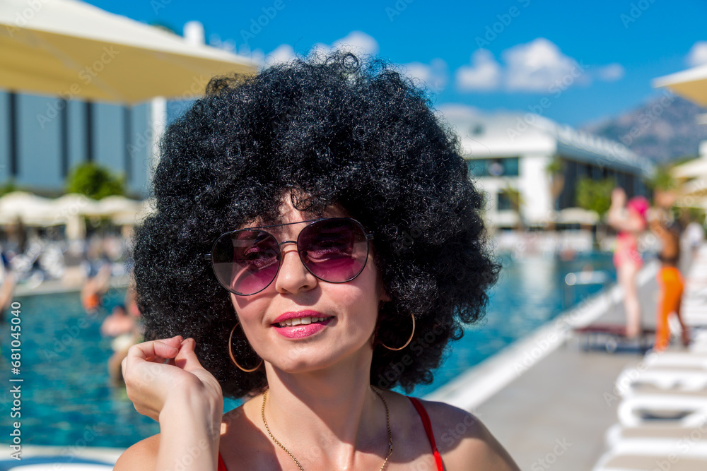 Bright cheerful girl animator near the pool, black lush curly curly hair and sunglasses. Bright cheerful girl animator near the pool, black lush curly curly hair and sunglasses.
