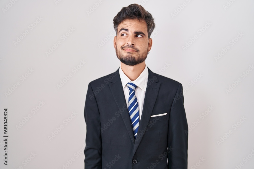 Young hispanic man with tattoos wearing business suit and tie smiling looking to the side and staring away thinking. Young hispanic man with tattoos wearing business suit and tie smiling looking to the side and staring away thinking.