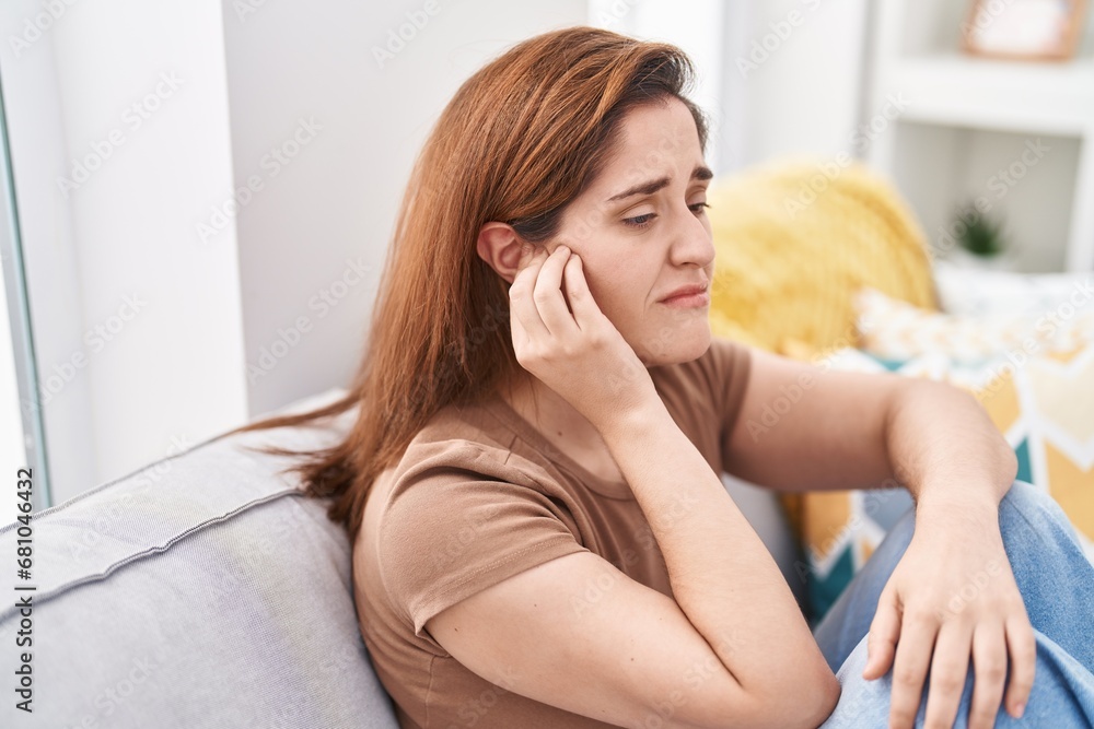Young woman suffering for ear pain at home