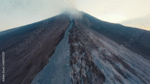 Aerial morning view approaching eruption volcano peak smoke disaster explosion sunrise. FPV sport drone high shot active volcanic crater summit natural gas stream danger heat air extreme landscape 4k