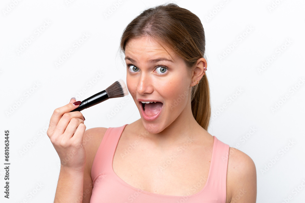 Young caucasian woman isolated on white background holding makeup brush and surprised Young caucasian woman isolated on white background holding makeup brush and surprised