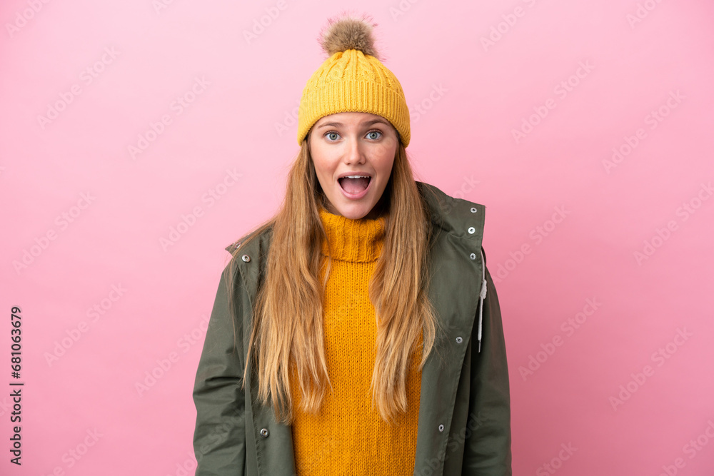 Young blonde woman wearing winter jacket isolated on pink background with surprise facial expression Young blonde woman wearing winter jacket isolated on pink background with surprise facial expression