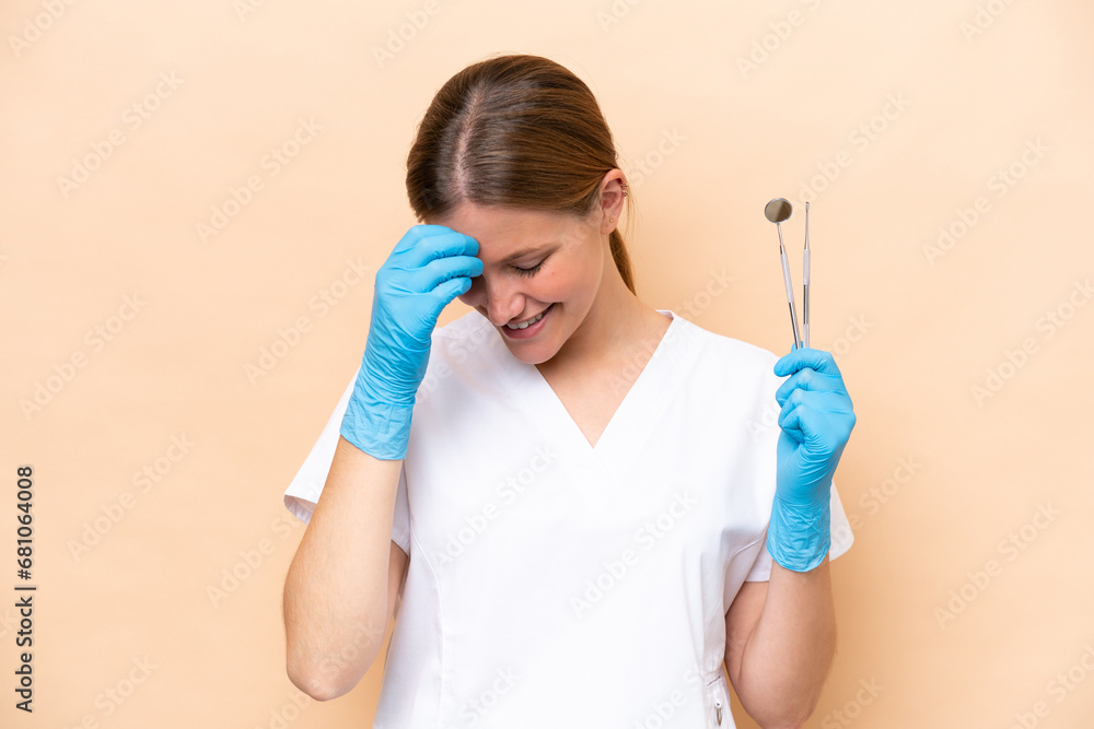 Dentist caucasian woman holding tools isolated on beige background laughing Dentist caucasian woman holding tools isolated on beige background laughing