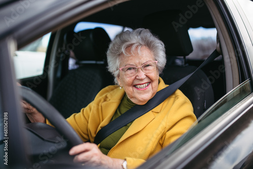 Happy senior woman driving car alone, enjoying car ride. Safe driving for elderly adults, older driver safety.