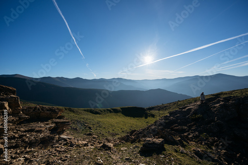 Canvas-taulu Beautiful scenery with mountains and airplanes' contrails on clear blue sky