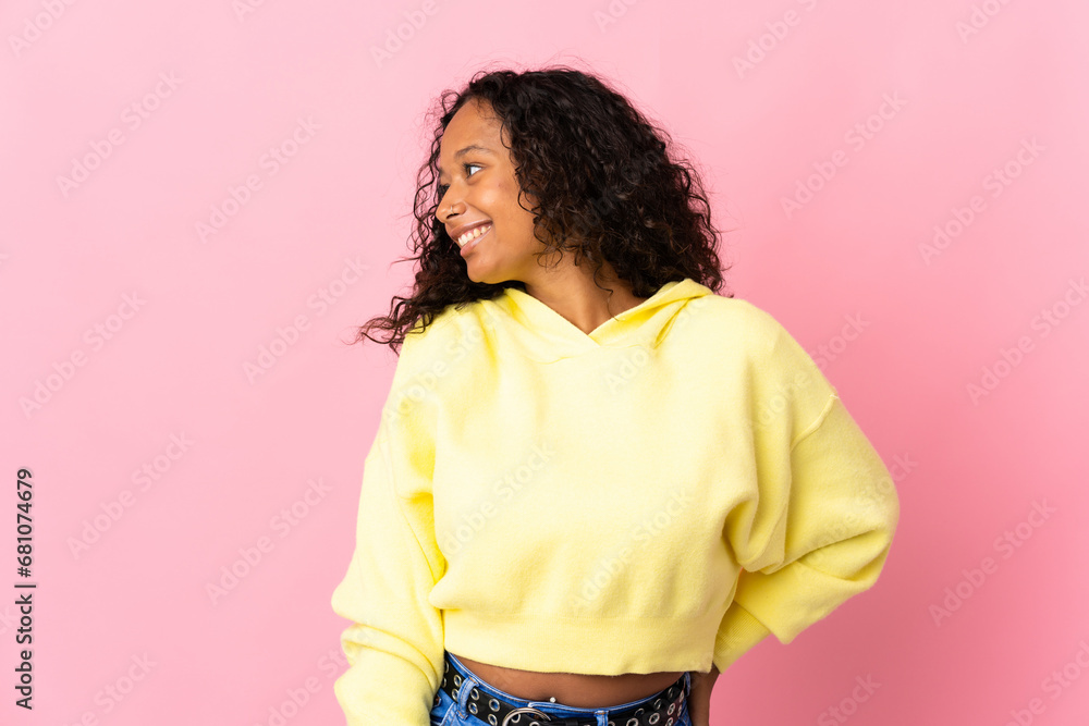 Teenager cuban girl isolated on pink background looking to the side and smiling Teenager cuban girl isolated on pink background looking to the side and smiling