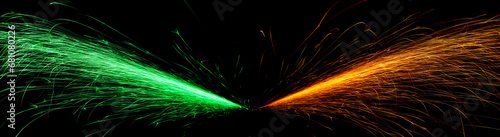 red and green fast-flying sparks from angle grinders on black background
