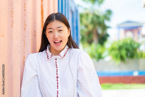 Young Chinese woman at outdoors with surprise facial expression photo