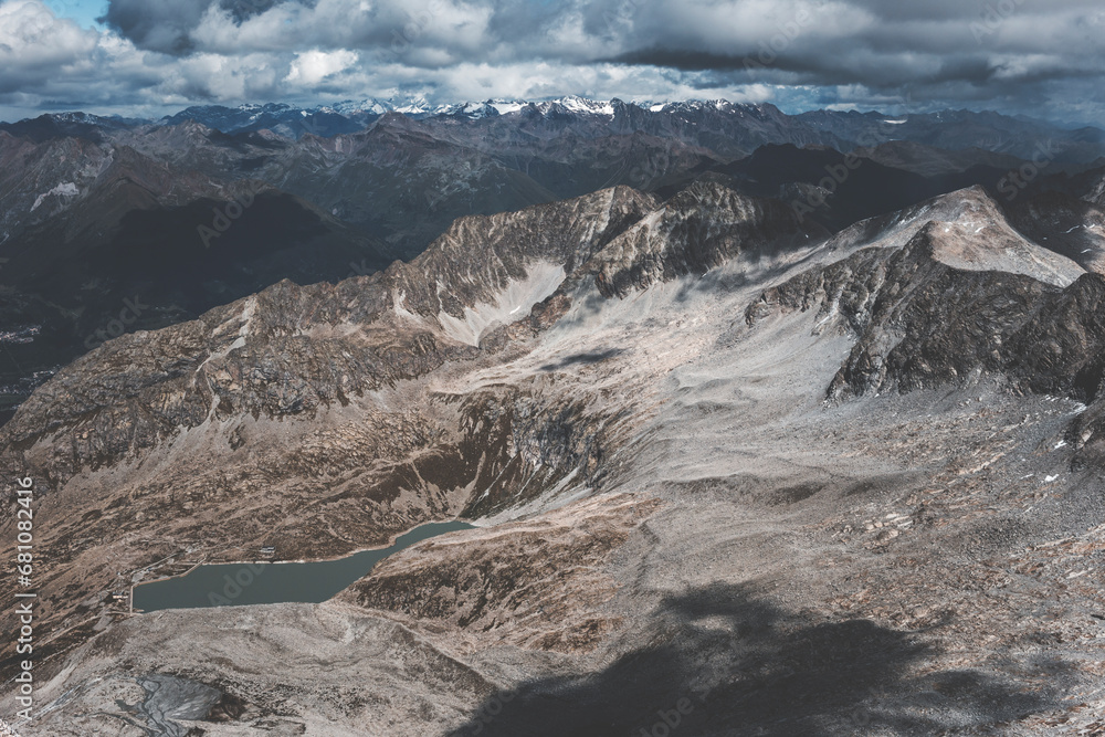 panoramic view of rocky mountains in the alps on a cloudy day with highlights and approaching storm