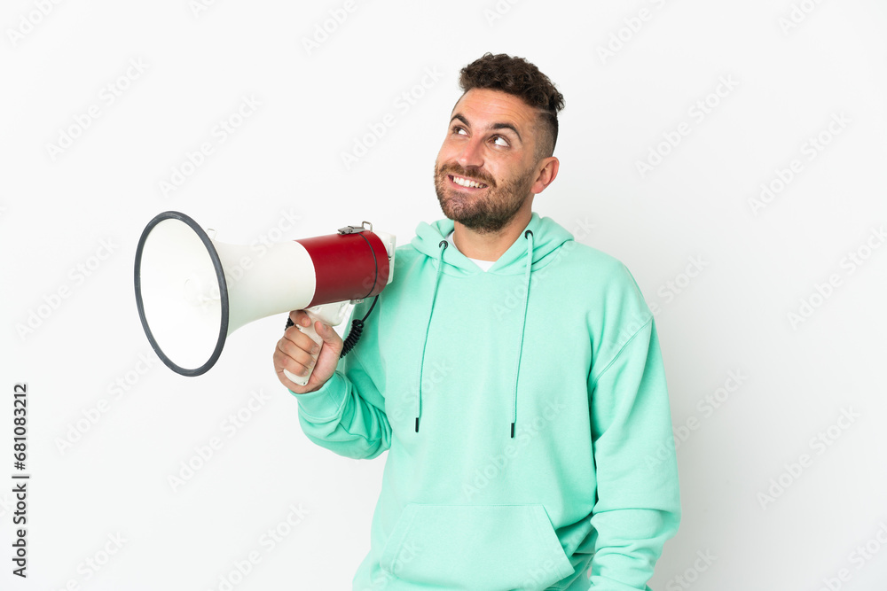 Caucasian man isolated on white background holding a megaphone and looking up while smiling Caucasian man isolated on white background holding a megaphone and looking up while smiling