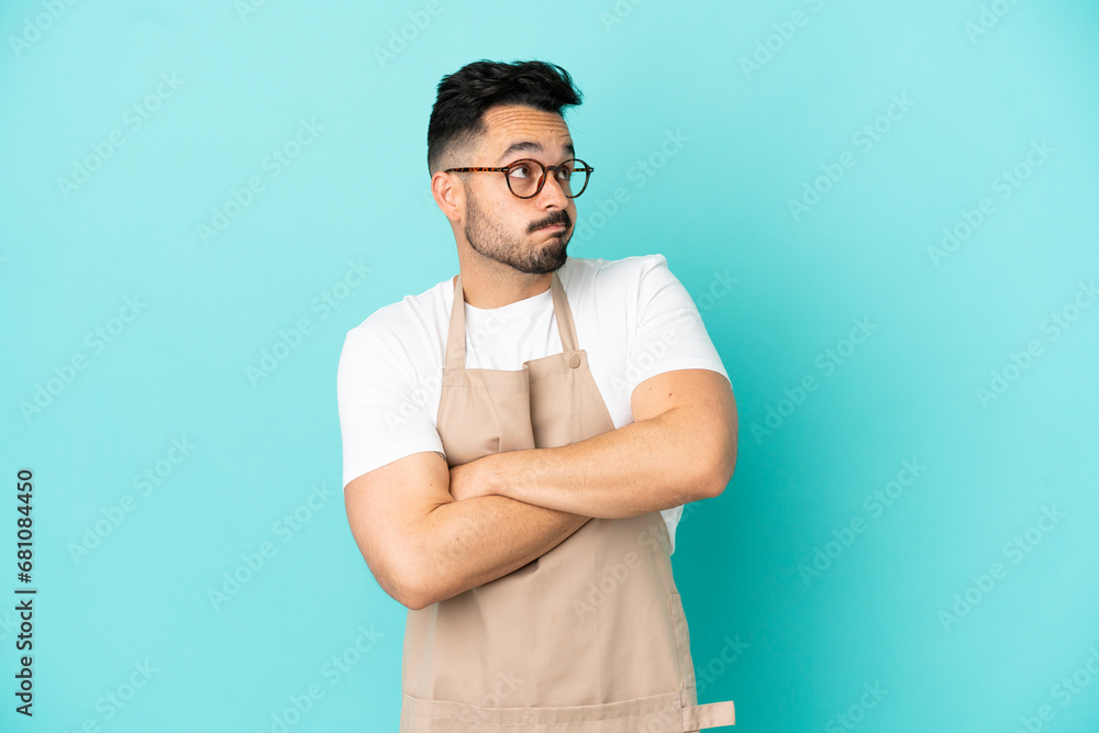 Restaurant waiter caucasian man isolated on blue background making doubts gesture while lifting the shoulders Restaurant waiter caucasian man isolated on blue background making doubts gesture while lifting the shoulders