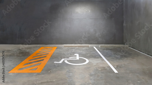 Reserve parking lot for disabled at modern building basement, international symbol or universal sign for handicapped parking painted on the concrete floor photo