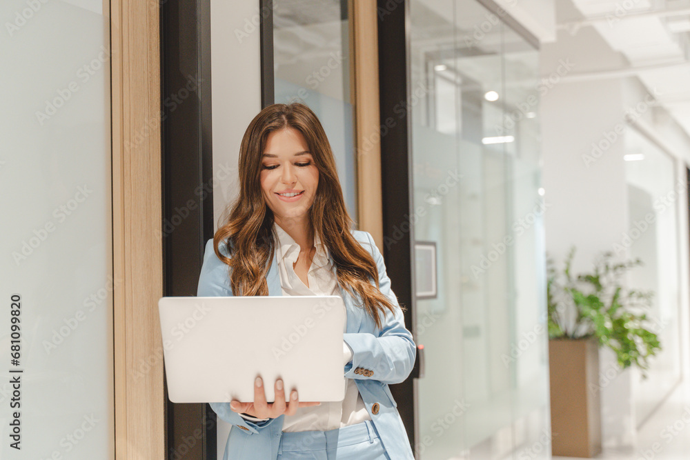 Portrait of smiling stylish American woman using laptop, working on computer Portrait of smiling stylish American woman using laptop, working on computer