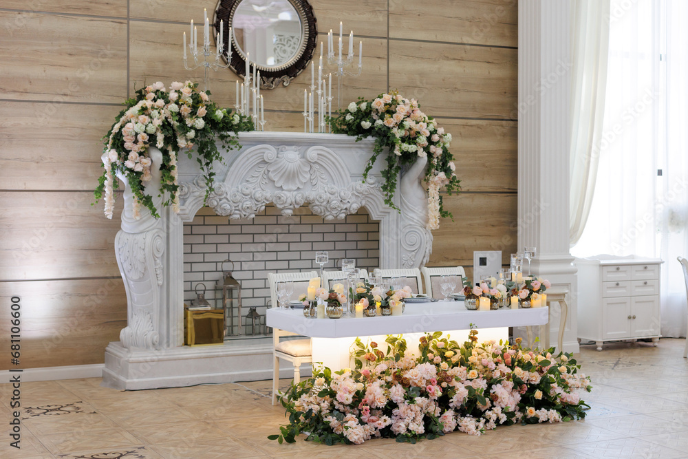 Naklejka premium Wedding ceremony. Presidium for the newlyweds, decorated with candles and vases with white and pink natural flowers such as eustoma, hydrangea, roses. Floristic concept