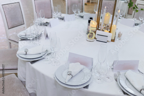Wedding decorations. Served wedding table with decorative  white napkins, envelopes and candles. Celebration details © Olga Pulchina