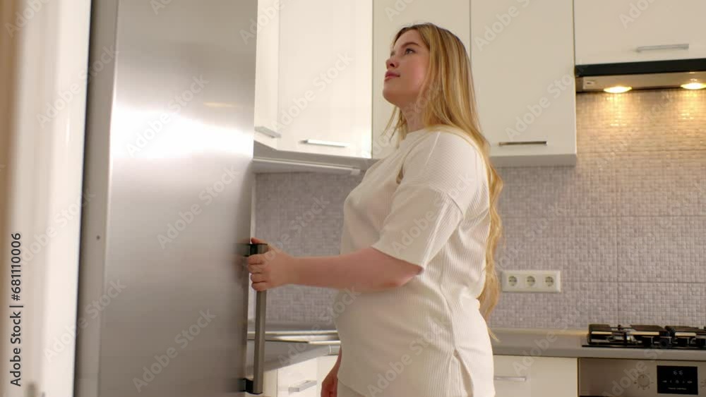 Young woman taking gallon of milk from refrigerator in kitchen. Young woman taking gallon of milk from refrigerator in kitchen.