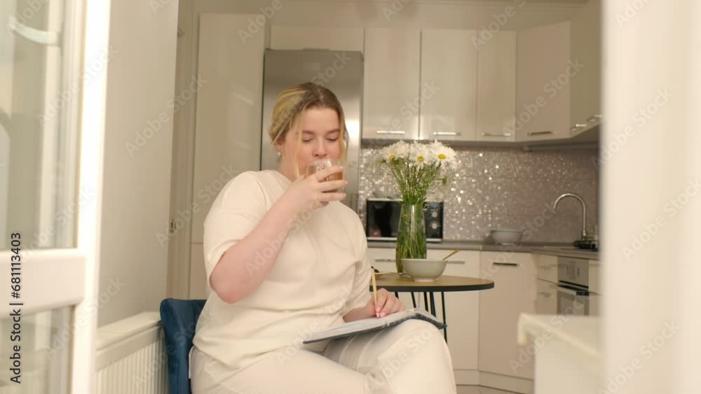 Portrait of smiling young woman holding cup of hot tea in hands in the morning in a kitchen Portrait of smiling young woman holding cup of hot tea in hands in the morning in a kitchen