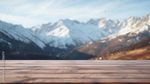 Close up wooden table with snowy mountains in the background, cloudy sky, high quality.  © Yacine