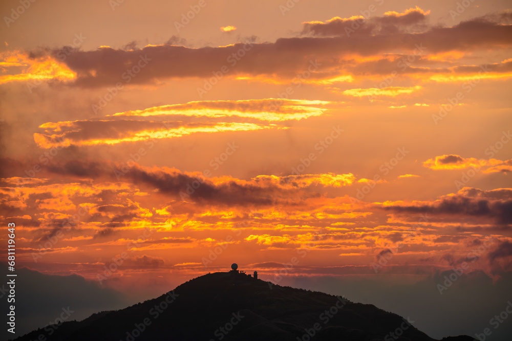 Orange-red sky, sunset and silhouettes of mountains. Wufenshan Weather Radar Station, Ruifang District, New Taipei City, Taiwan.