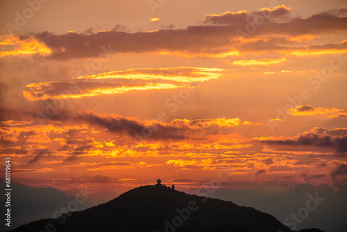 Orange-red sky, sunset and silhouettes of mountains. Wufenshan Weather Radar Station, Ruifang District, New Taipei City, Taiwan.