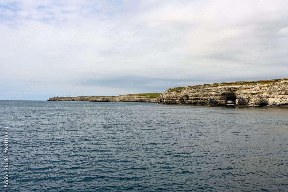 Cape Tarkhankut on the Crimean peninsula. The rocky coast of the Dzhangul Reserve in the Crimea. The Black Sea. Turquoise sea water. Rocks and grottoes of Cape Tarkhankut. Cape Tarkhankut on the Crimean peninsula. The rocky coast of the Dzhangul Reserve in the Crimea. The Black Sea. Turquoise sea water. Rocks and grottoes of Cape Tarkhankut.