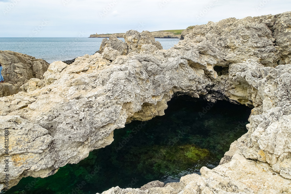 Cape Tarkhankut on the Crimean peninsula. The rocky coast of the Dzhangul Reserve in the Crimea. A sunny summer day. The Black Sea. Turquoise sea water.