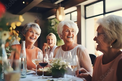 Happy senior diverse women drinking wine and laughing together in restaurant