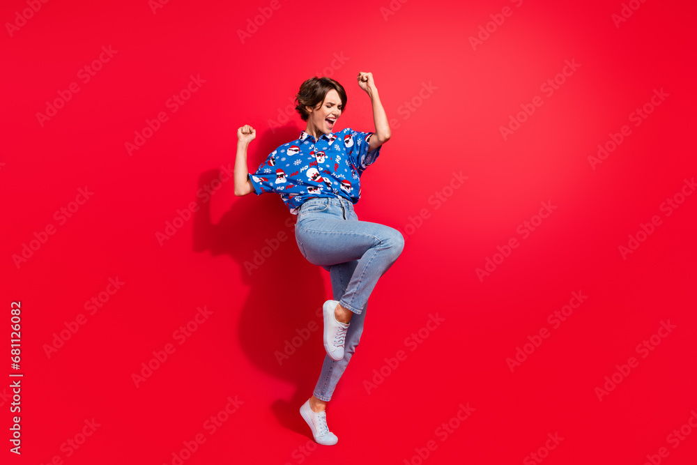 Full body photo of scream young girl brown bob hair raised fists up trophy awesome night magic christmas isolated on red color background