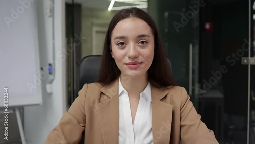 Young woman listening to webcam, participating in videoconference. Head shot portrait girl negotiating with clients using Video call nodding