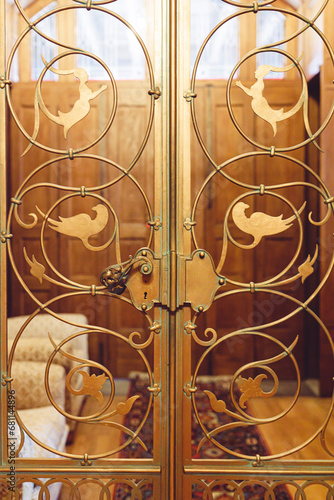 A Glittering Entrance to the Peles Castle: Ornate Gold Doors Adorned with Delicate Birds
