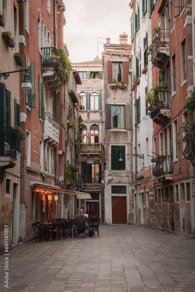 Fototapeta premium An atmospheric view of an empty street in Venice, Italy. The photo captures the timeless beauty of the city with its charming architecture and tranquil canals.