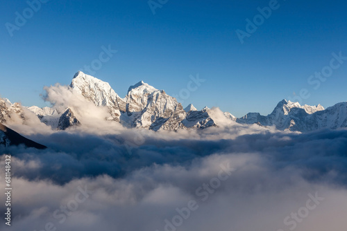 Snowy himlayan peaks in the sea of clouds. Beautiful landcape in Nepal on Everest Base Camp trek. photo