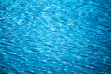 Background of sea blue water with sparkles of the sun on the waves.