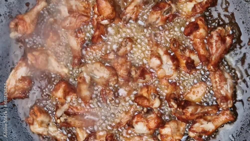 Chicken wings frying in a big pan with vegetal oil bubble Chicken wings frying in a big pan with vegetal oil bubble